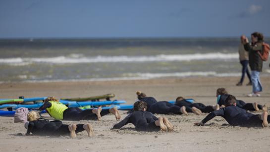 Surfers leren op het strand